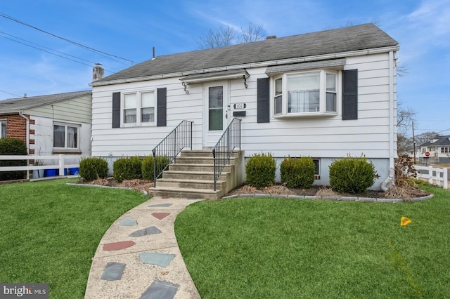 bungalow-style house with a front lawn, fence, and a shingled roof