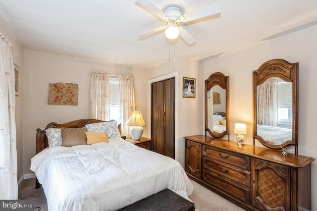 bedroom with multiple windows, light colored carpet, a closet, and ceiling fan