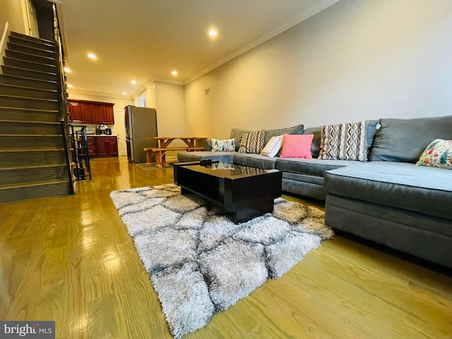 living room featuring stairs, recessed lighting, light wood-style flooring, and crown molding