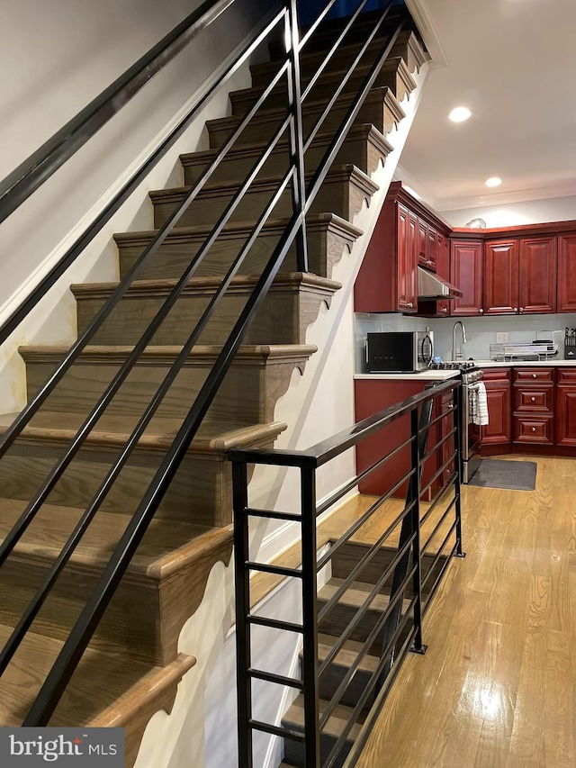 stairway with recessed lighting and wood finished floors