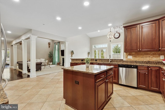 kitchen featuring light tile patterned floors, decorative columns, a center island, stainless steel dishwasher, and a sink