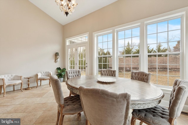 dining room with high vaulted ceiling, light tile patterned floors, baseboards, and a notable chandelier