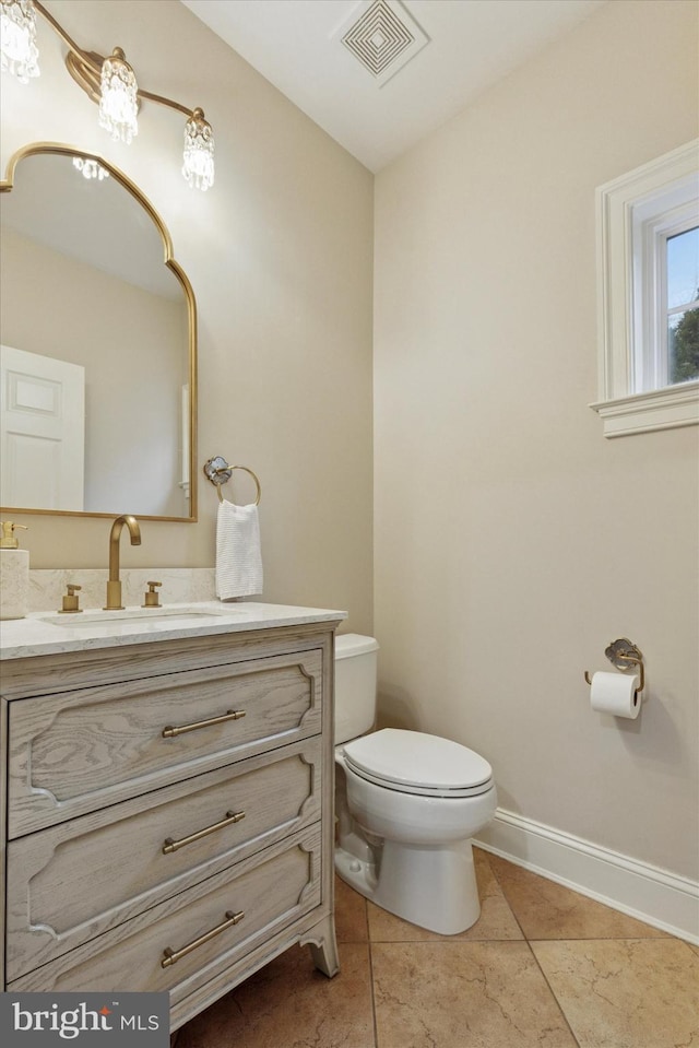 bathroom featuring tile patterned flooring, toilet, vanity, visible vents, and baseboards