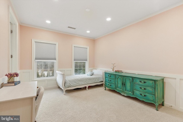 bedroom featuring wainscoting, light carpet, crown molding, and visible vents