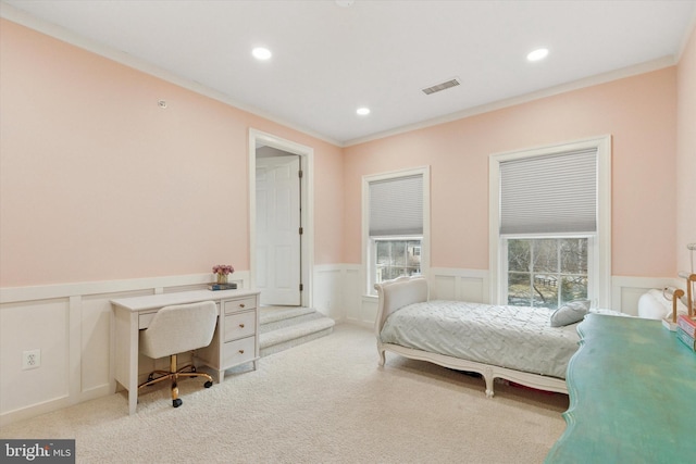 carpeted bedroom featuring a wainscoted wall, visible vents, ornamental molding, and recessed lighting