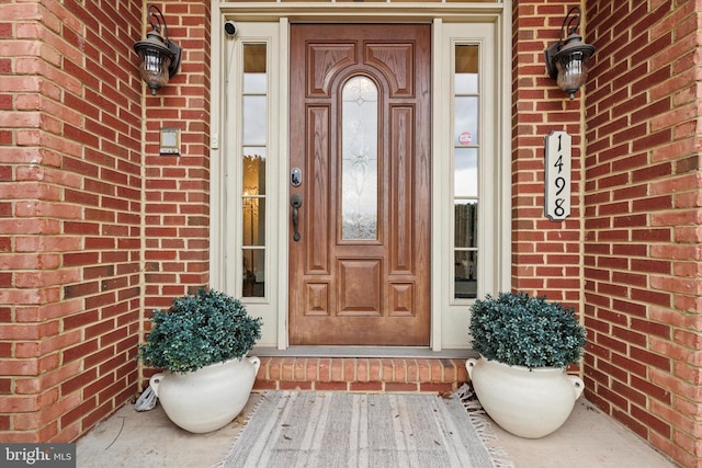 view of exterior entry featuring brick siding