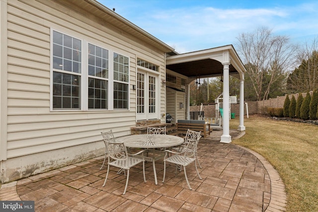 view of patio / terrace with outdoor dining space, french doors, fence, and entry steps