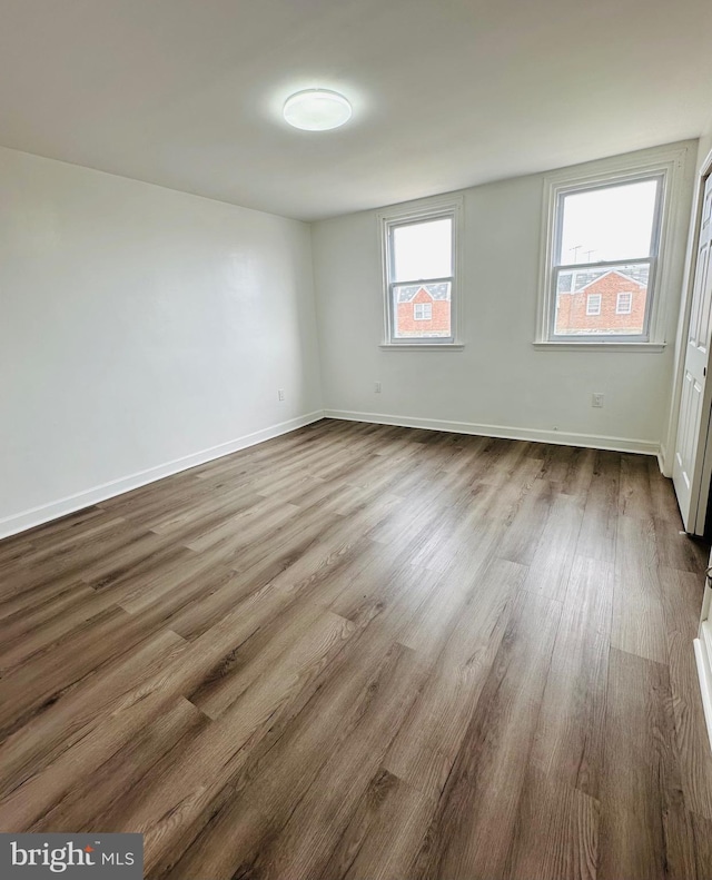 unfurnished room featuring baseboards and wood finished floors