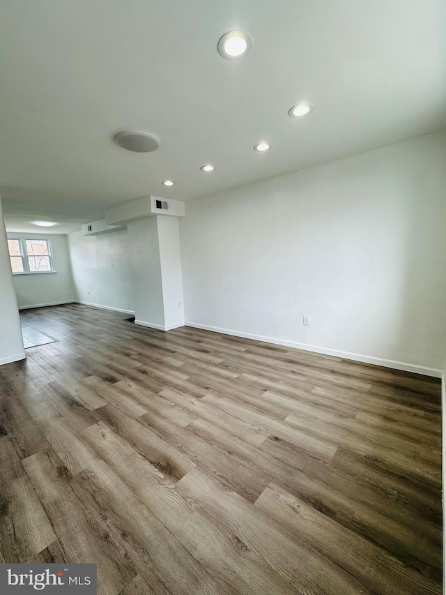 empty room with light wood finished floors, visible vents, baseboards, and recessed lighting