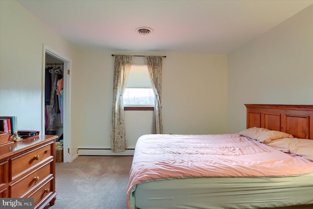 carpeted bedroom with a baseboard heating unit and visible vents