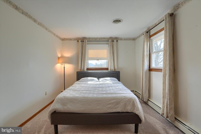 carpeted bedroom with a baseboard radiator, multiple windows, a baseboard heating unit, and baseboards