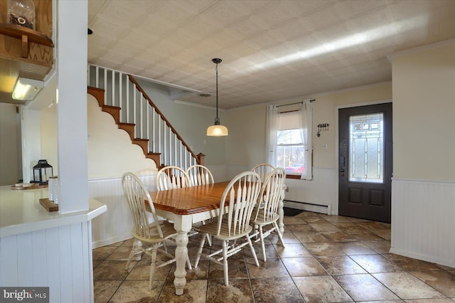 dining room featuring a baseboard radiator, stairway, ornamental molding, and wainscoting