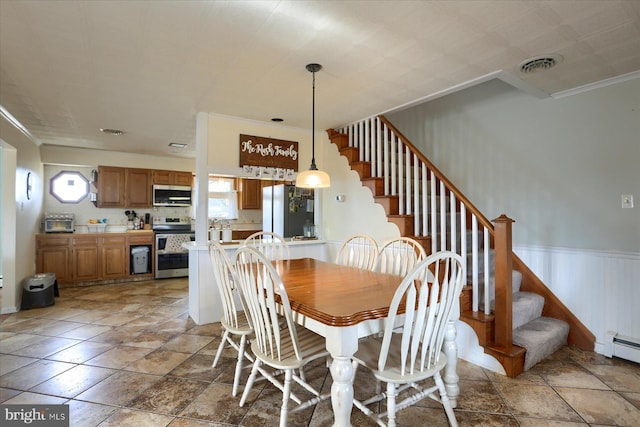 dining room with a toaster, visible vents, wainscoting, stairway, and crown molding