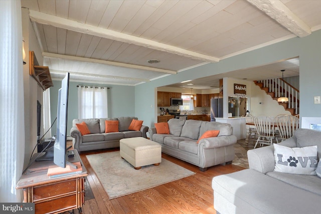 living area with wood ceiling, light wood-style flooring, stairway, and beam ceiling