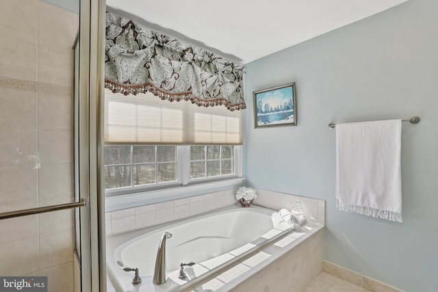 full bath with tile patterned floors, tiled shower, baseboards, and a bath