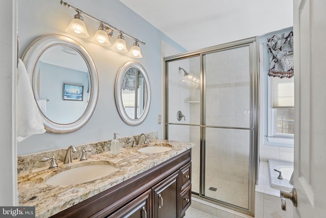 bathroom with double vanity, tile patterned floors, a sink, and a shower stall