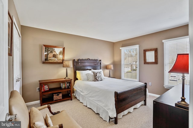 bedroom with light colored carpet and baseboards