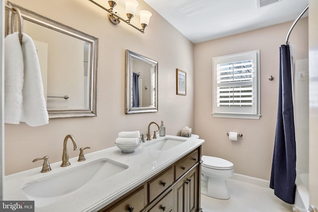 full bathroom with toilet, double vanity, visible vents, and a sink