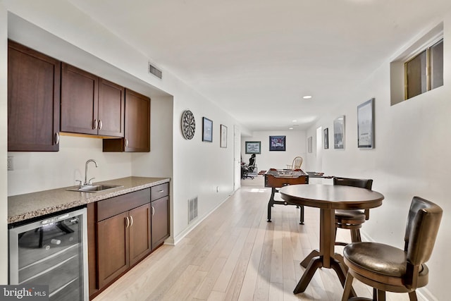 interior space with visible vents, dishwasher, light wood-style flooring, and a sink