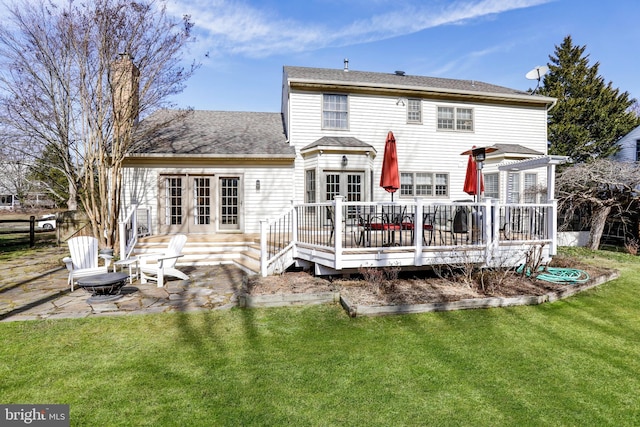 rear view of property with a patio, fence, a yard, french doors, and a wooden deck