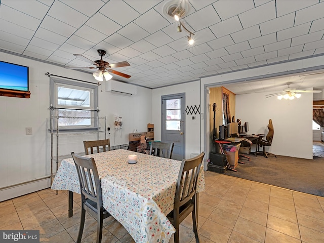 dining space with ceiling fan, light tile patterned floors, a wall mounted AC, and light colored carpet