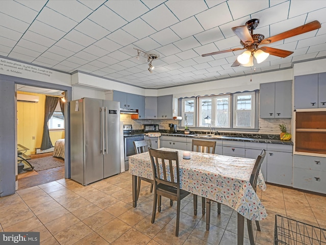 kitchen with decorative backsplash, dark countertops, high quality fridge, gray cabinets, and range with electric stovetop