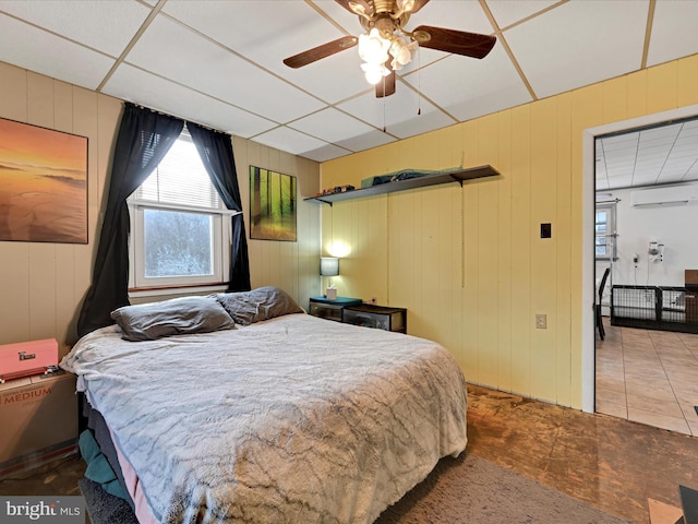 bedroom featuring a wall mounted air conditioner, ceiling fan, and tile patterned floors