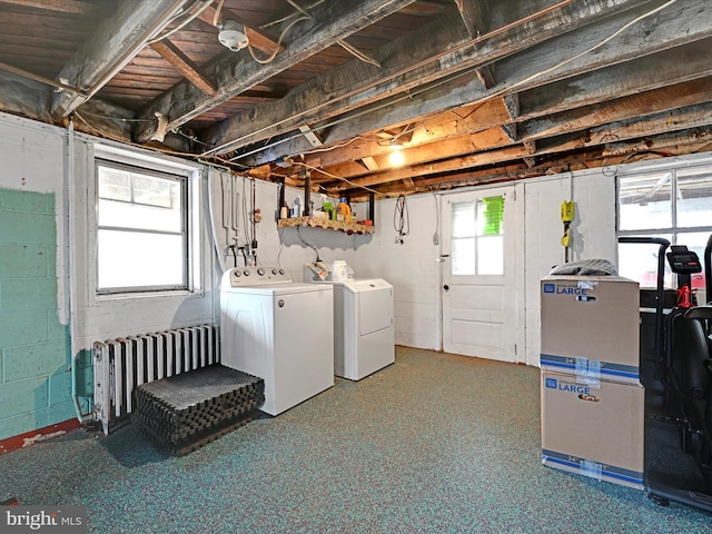 basement with radiator, plenty of natural light, and separate washer and dryer