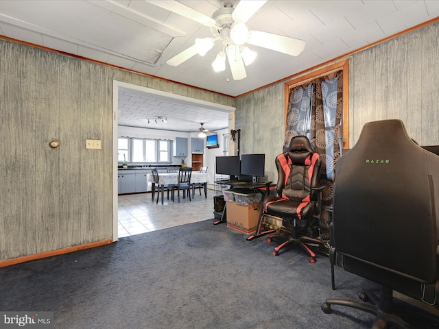 office area with ceiling fan, light colored carpet, wood walls, and light tile patterned flooring