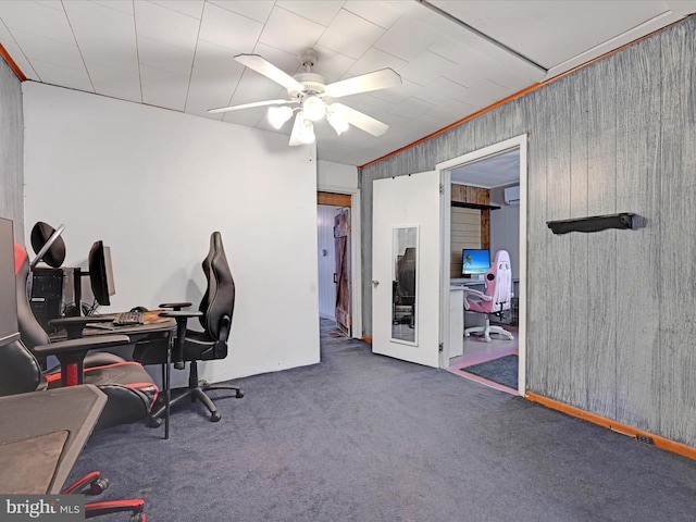 office area featuring ceiling fan, wood walls, a wall mounted AC, dark colored carpet, and crown molding