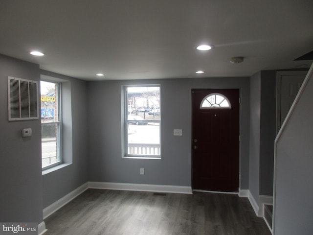 foyer featuring a wealth of natural light, baseboards, visible vents, and dark wood-style flooring