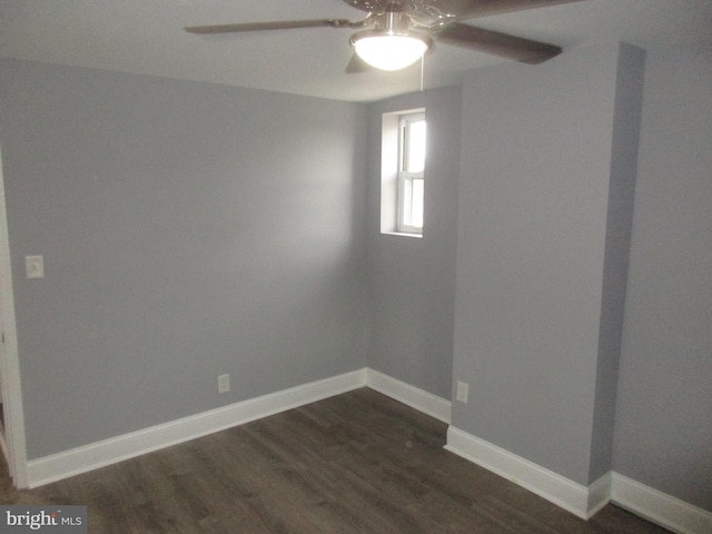 empty room with dark wood finished floors, baseboards, and ceiling fan