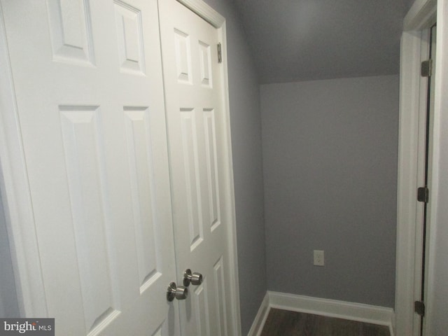 interior space featuring dark wood finished floors, vaulted ceiling, and baseboards