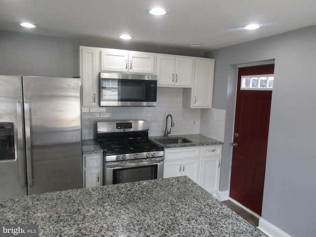 kitchen featuring stainless steel appliances, a sink, and white cabinets