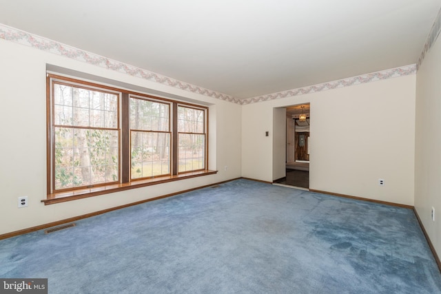 carpeted empty room featuring baseboards and visible vents