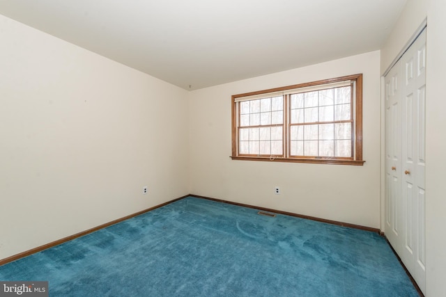 unfurnished bedroom featuring a closet, carpet floors, visible vents, and baseboards