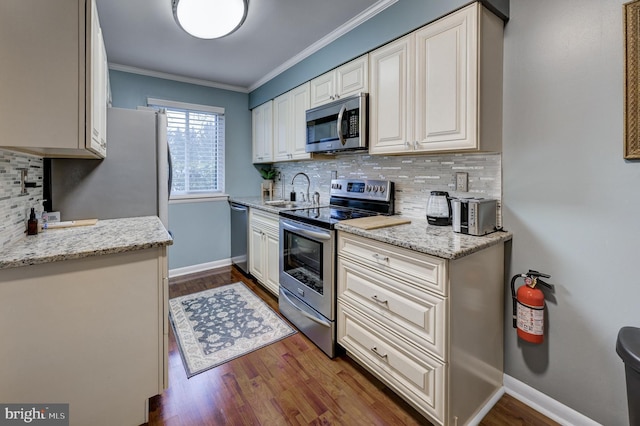 kitchen featuring a sink, stainless steel appliances, dark wood-type flooring, and ornamental molding