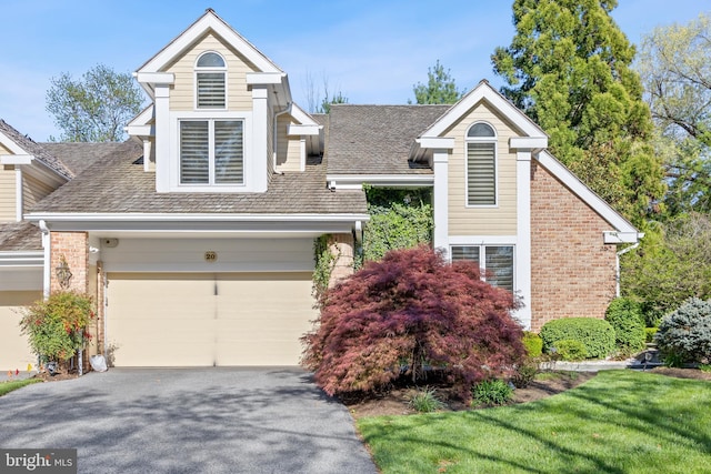 view of front of house with driveway and brick siding