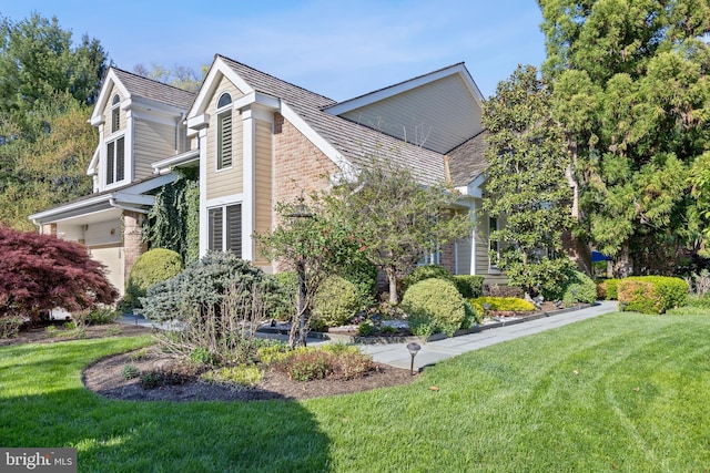 view of side of home featuring a lawn and brick siding