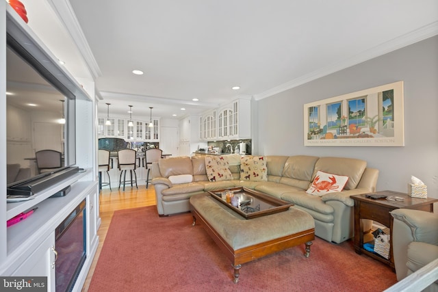 living area featuring crown molding, light wood finished floors, and recessed lighting