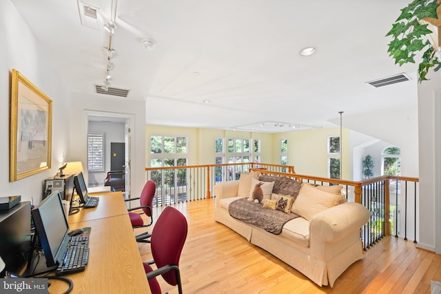 living area with rail lighting, wood finished floors, and visible vents