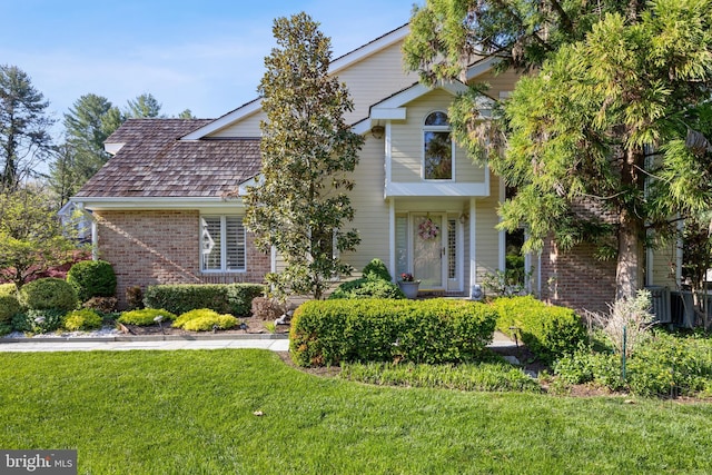 view of front facade with a front yard and brick siding