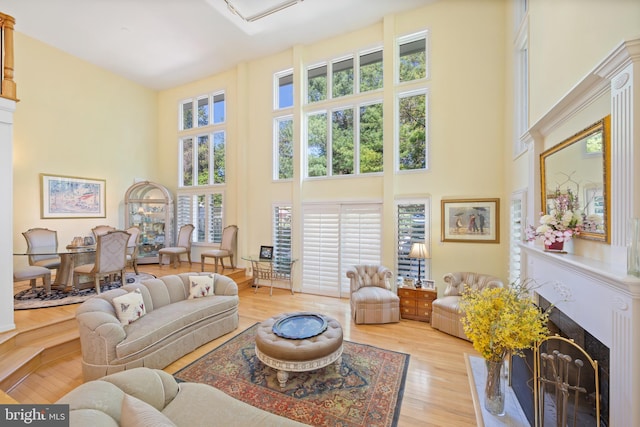 living room featuring a wealth of natural light, a premium fireplace, and a high ceiling
