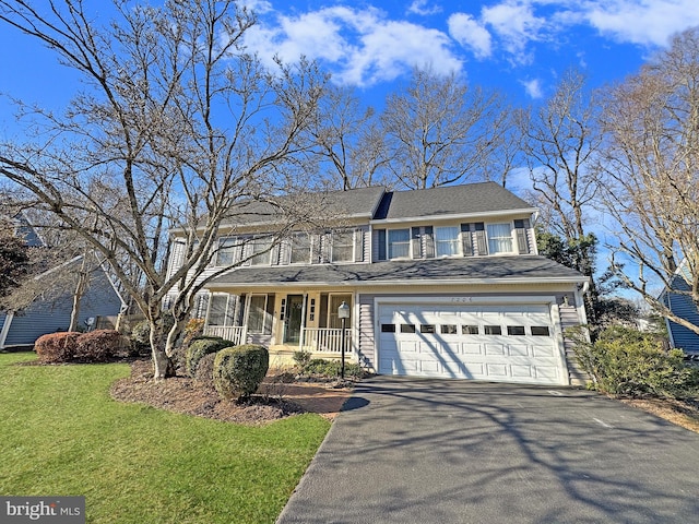 view of front facade with covered porch, driveway, an attached garage, and a front yard