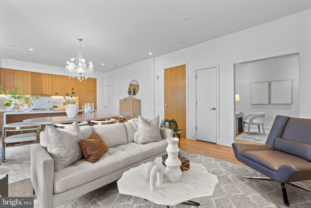 living area featuring recessed lighting, light wood-style floors, and an inviting chandelier