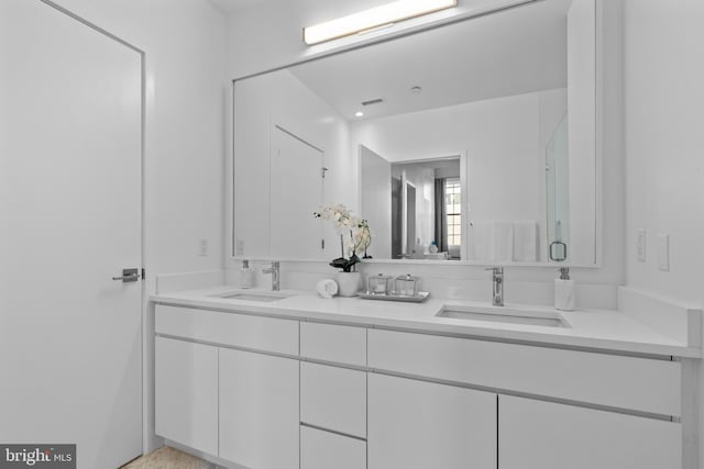 bathroom featuring double vanity, visible vents, and a sink