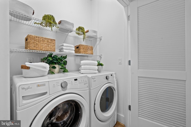 clothes washing area with washer and clothes dryer and laundry area