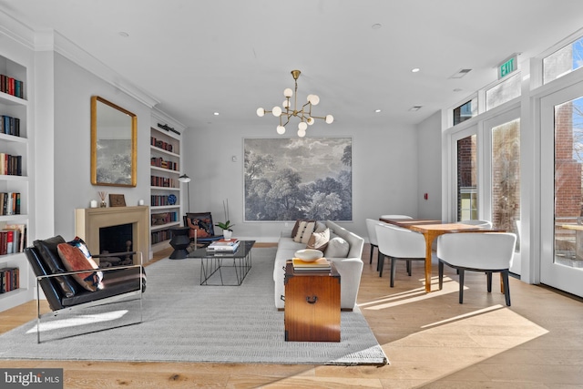 living area with built in features, wood finished floors, a chandelier, and recessed lighting