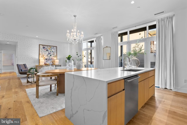 kitchen with light wood finished floors, open floor plan, french doors, modern cabinets, and a sink