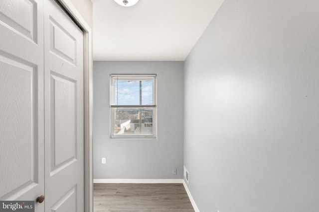 unfurnished room featuring visible vents, baseboards, and wood finished floors